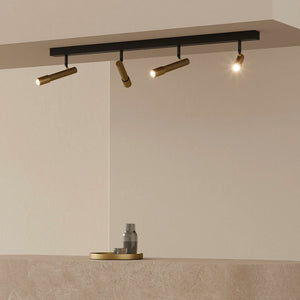 contemporary steel spotlight bar over a kitchen island with black and brass finish