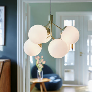 modern 6 mouth-blown globe chandelier with brass finish in a living room