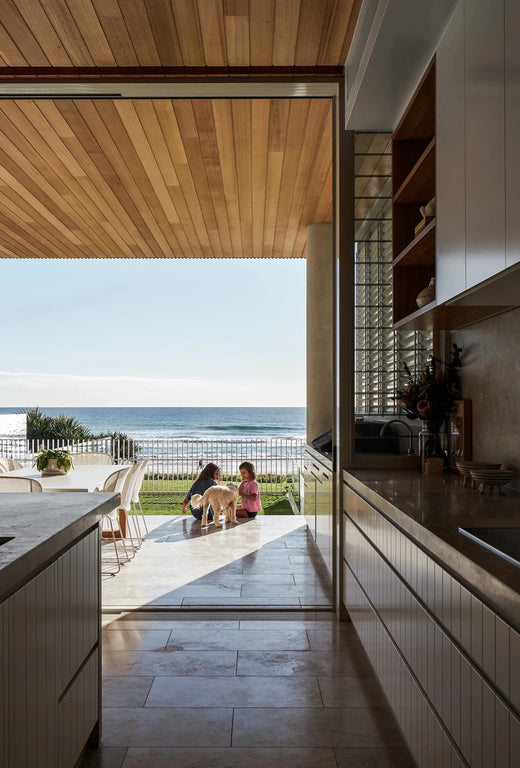 Timber linear pendant light in a modern kitchen with ocean view