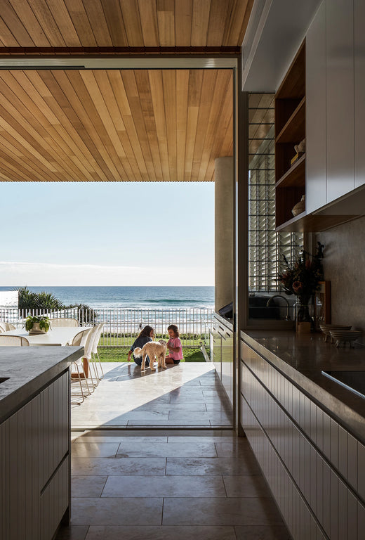 Timber linear pendant light in a modern kitchen with ocean view