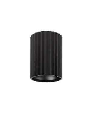 Small black cylindrical ribbed light fixture on a white background