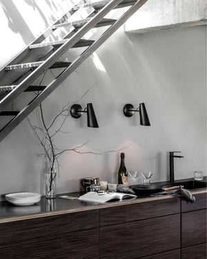 Modern kitchen with dark wood cabinets, black countertop, and 1952 Scandinavian Designed Wall Lights