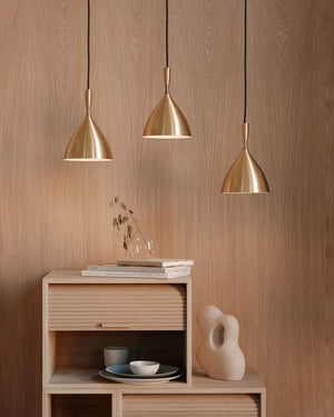 Three 1954 Original Scandinavian Pendant Lights hanging above a wooden cabinet with decor items on a wooden wall background.
