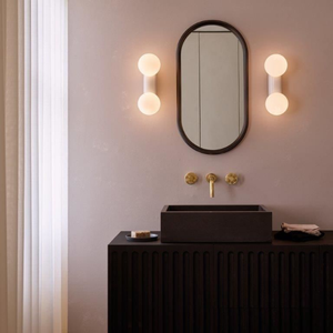 Glossy White Orb Dual Wall Lights in a bathroom on both sides of a mirror