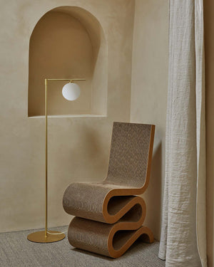 Modern chair and floor lamp against a neutral wall with archway