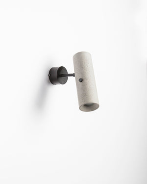 Wall-mounted light fixture with concrete-like finish on a white background