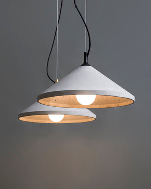 Two pendant lights with concrete bases on a gray background