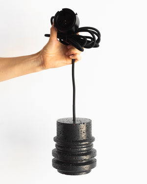 Person holding a Buzao Circle Black Lava Pendant