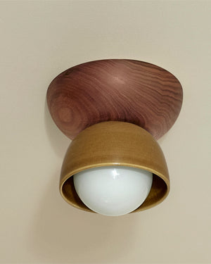Wooden ceiling light fixture with a white bulb on a beige background