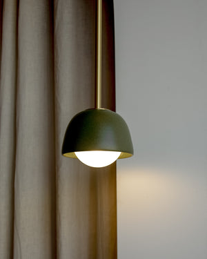 Olive ceramic pendant on beige curtain and white wall 