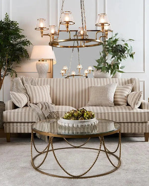 Living room with striped sofa, round glass coffee table, and decorative elements.