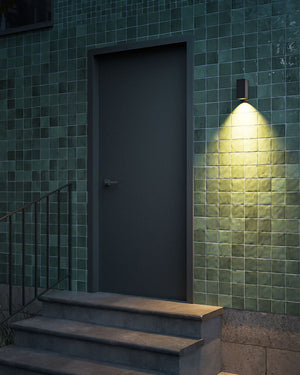 Dark door with green tiled wall and Down Light fixture casting a glow - Lighting Collective 