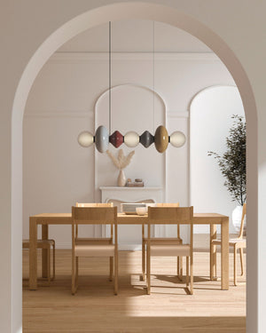 Dining area with wooden table and chairs, modern pendant light, and archway.