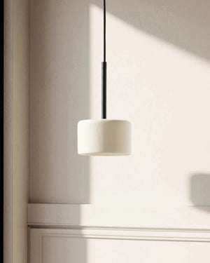 Minimalist pendant light hanging in a softly lit room