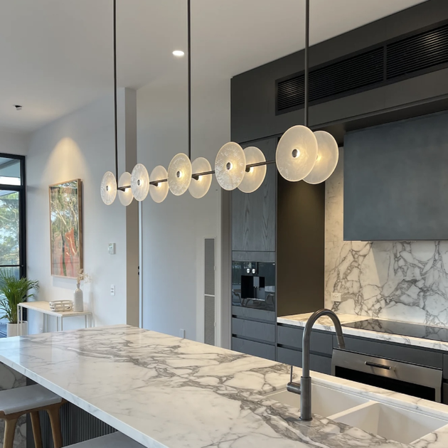 Coral 10lt Linear Rod Pendant | Lighting Collective | matte black light on and frosted glass over a kitchen island