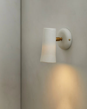 Wall-mounted dusked evo ceramic light fixture with a white shade and gold fixture on a neutral wall.