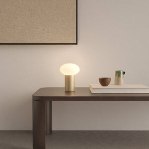 Glass Pebble and Aluminium Portable Table Lamp light bronze lit up on a console table