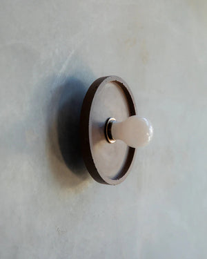 Round concrete wall light on a light gray background