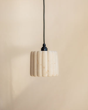 Pendant light with ribbed design on a beige background
