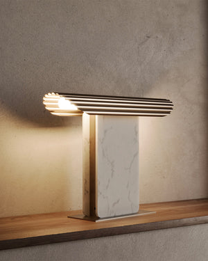 Modern table lamp with marble base on a wooden surface and concrete wall background