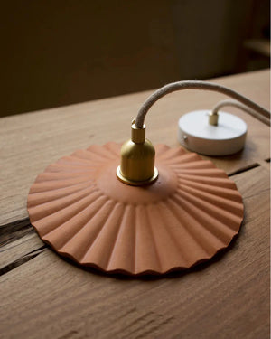 handmade leather pendant sitting on a table with a withe ceiling plate
