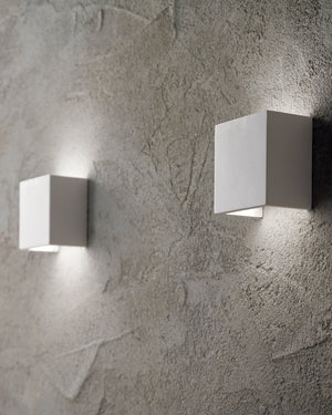 Two square wall lights on a textured gray wall