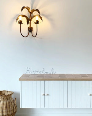 White cabinet with wooden countertop and wall-mounted light fixture against a white wall.