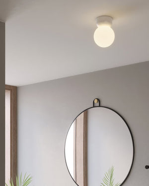 Glossy White Orb Ceiling Light installed on a ceiling above a round mirror