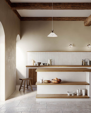 Opal white glass and brass cone pendant displayed over a kitchen island