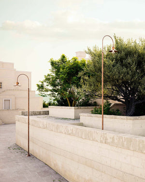 Traditional Italian lamp posts in a public space surrounded by trees