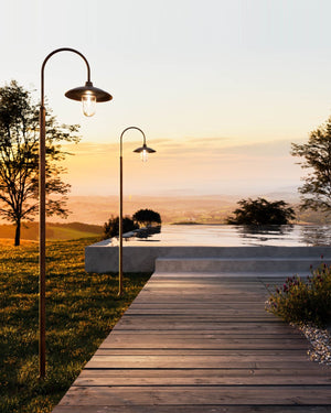 Italian lamp posts on a pathway leading to an infinity pool at sunset hour