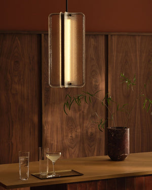 Textured Reeded Glass Column Pendant with an antiqued brass detail hanging over a bar