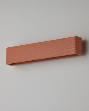 Rectangular timber sconce with terracotta finish on grey background