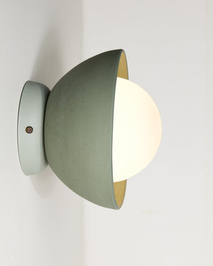 Modern wall-mounted Studio Enti light fixture with a mint & lotus finish on a white background