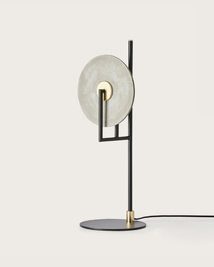 Modern table lamp with marble shade and black base on a white background