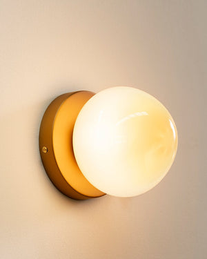 Wall-mounted light fixture with a warm glow on a neutral background