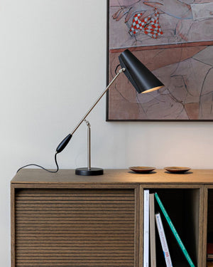 Mid-Century Adjustable Table Lamp on a wooden sideboard with abstract art in the background