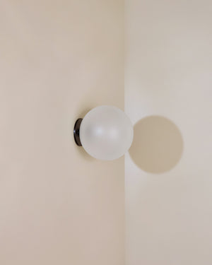 Frosted glass light fixture on a beige wall