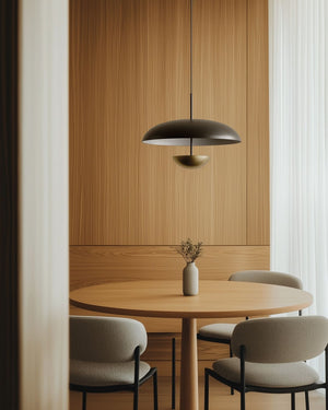 Modern dining area with round wooden table and chairs under a pendant light.