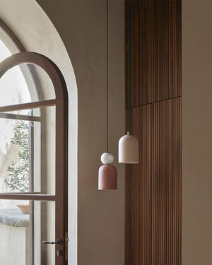 Two Minimalist Marble Ornament Pendant Lights hanging in a room with an arched window and wooden paneling.