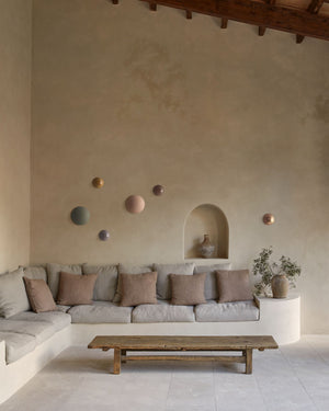 Modern living room with a neutral color palette, featuring a sofa, coffee table, and decorative wall art.