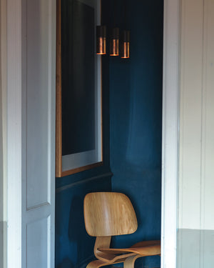 Wooden chair against a blue wall with a framed picture above it and 3 Italian Ceramic and Metal Pendant Light