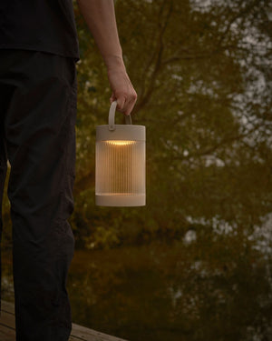 Person holding the Sand Solar top of the Portable Reeded Shade Table Lamp - Lighting Collective 