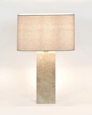 Table lamp with a textured beige shade and rectangular stone base on a white background