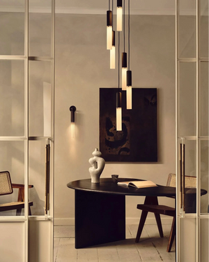 Modern interior design with a round black table, chairs, and Reeded Glass and Brass Cylindrical Chandelier Pendant