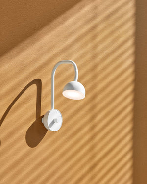 Scandinavian Adjustable Wall Lamp light fixture on a mustard wall with shadows.