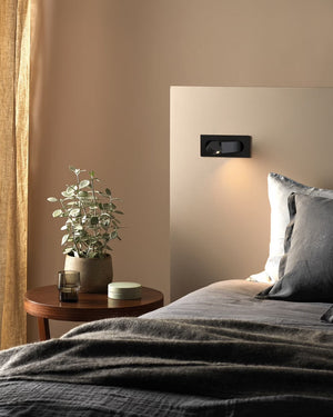Smart Adjustable Switched LED Wall Light in Matt black on a bed head