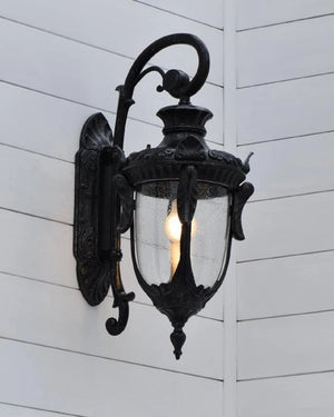 Decorative outdoor wall light fixture on a white wooden wall