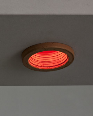 Red circular light fixture on a gray background