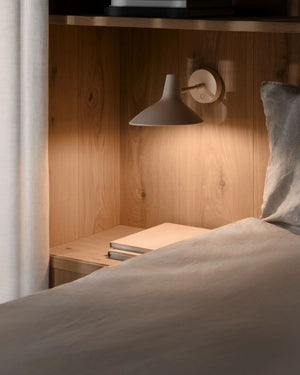 Adjustable Shaded Wall Light in sand finish mounted in timber bedroom nook casting warm downward light